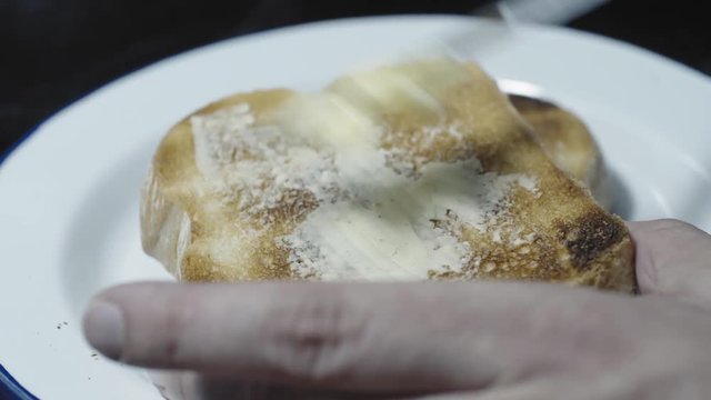 Prepareing toast in a home kitchen. Good quality bread and good quality butter. Cinematic lighting with suttle grading.