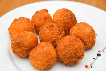 Cheese balls, Breaded mozzarella cheese balls with tomato in white dish on wood blackground