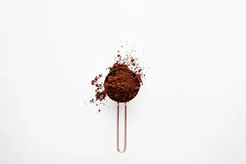 Schilderijen op glas Rose gold measuring cup of cocoa powder on a white background, healthy food concept © SEE D JAN