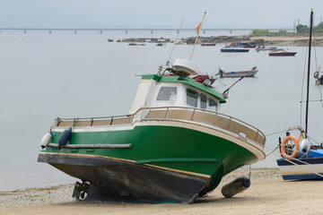 wooden fishing boat is drying on the beach