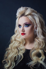 Fototapeta premium Portret młodej luksusowej blondynki z długimi lokami.
