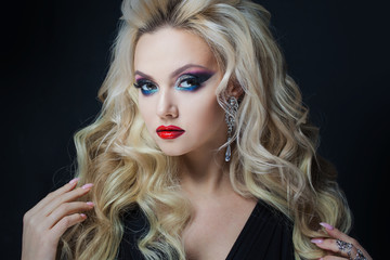 Fototapeta premium Portrait of a young luxurious blonde with long curls.