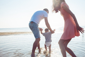 Mom and dad teach baby to walk