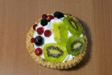 cream cake with kiwi and blueberries on a wooden table