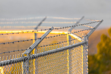Barbed wire fence surrounding a water tank on hill