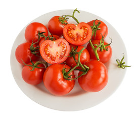 Red ripe tomato branch on a white plate isolated on white background. Concept of healthy food and vegetarian food, close up, top view.