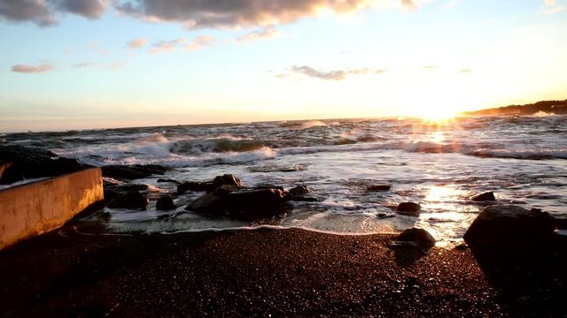 Atlantic Ocean waters wash up upon the shore in Cape Cod during a beautiful sunset.