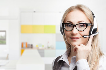 Three call center service operators at work. Portrait of smiling pretty female helpdesk employee with headset at workplace.