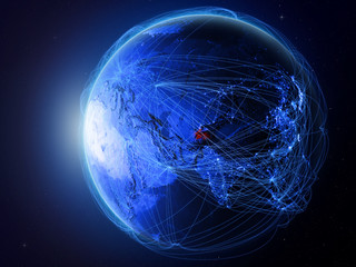 Tajikistan from space on planet Earth with blue digital network representing international communication, technology and travel.