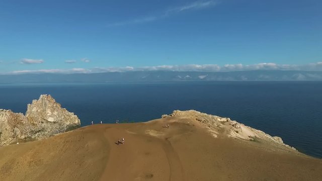 Aerial view of Shamanka Rock, Olkhon Island, Baikal lake. Scenic unique rock cliff edge, orange mountain, shamanic landscape. Famous Tourist explore.