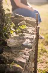 Girl Seated, Stone Wall, Early Morning Sunlight