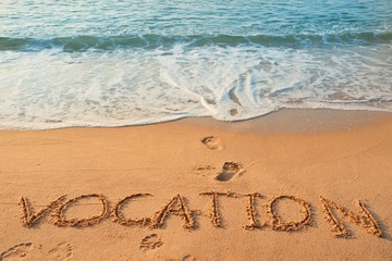 The word Vocation handwriting on sand beach with blue waves background.