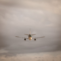 Fototapeta premium Symmetrical central composition. The plane flies into the clouds. Copy space fot text