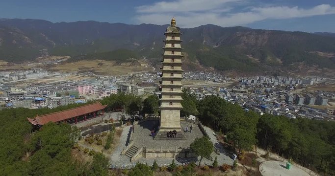 Aerial Pullback Tourist Sat at the Base of a Beautiful Hilltop Temple in Weixi Lisu, China.