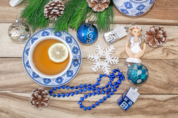 New Year's table with fir branches and decorations on a wooden background. Christmas tea with cookies, gingerbread, small stars. Festive background in blue tones.