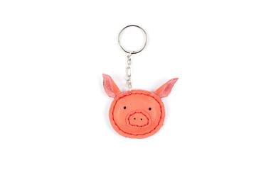 Keychain in form of cute little pig on white background