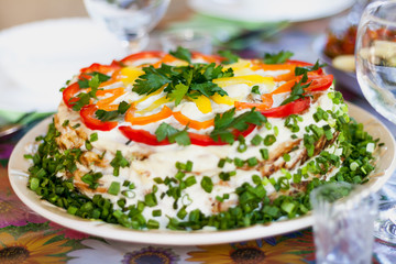 Appetizing layered salad on round plate