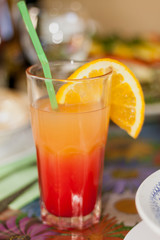 Tall glass with cocktail is on table