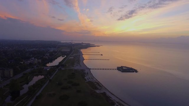 Aerial shot of Malmo beach Ribersborg and the piers with kallbadhuset and the bridge Bron in the background in 4k