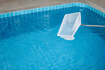 cleaning swimming pool with scoop net