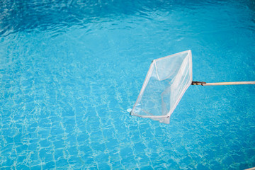 cleaning swimming pool with scoop net