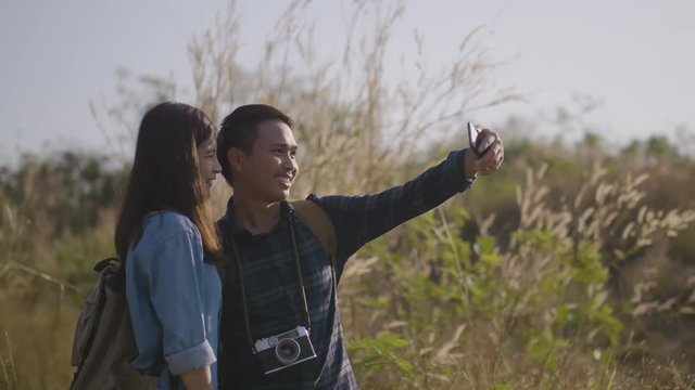 Asian couples are posing together to take photo with smartphone