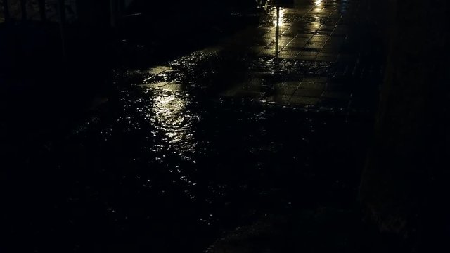Puddle in the city at night with rain downfall