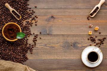 Coffee concept. Roasted beans, ground coffee and cup of espresso on wooden background top view copy space