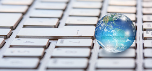Glass globe on laptop keyboard "Elements of this image furnished by NASA "