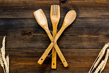Fork, spoon in woodenware set on wooden background top view