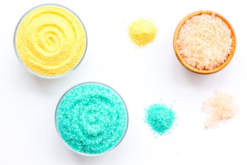 Colorful bath salt blue and yellow on white background top view