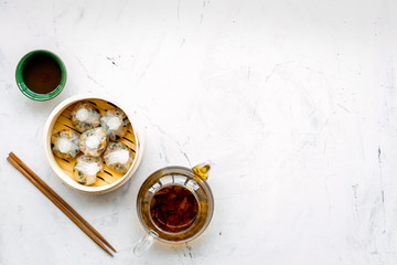 Dinner in Chinese restaurant with dim sum, sticks and herbal tea on marble background top view...