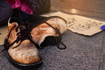 Label “Help please” word with dollar , hat and Old shoes for homeless.
