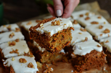 A piece of carrot cake with icing and nuts