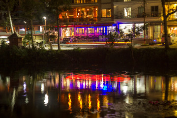 Fototapeta na wymiar colorful reflection in the lake of lights of the night city on the shore