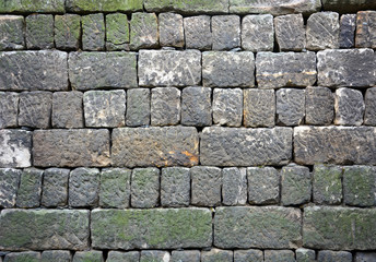 texture of old stone wall layer covered green moss