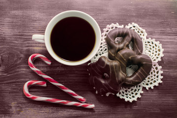 Cup of coffee and delicious gingerbreads with candy sticks. Spice cupcakes. Christmas concept - festive gingerbreads with a cup of coffee.