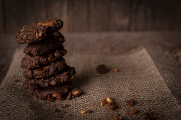 Cookies chocolate of cashew nut are arranged on a sack on a wooden table.