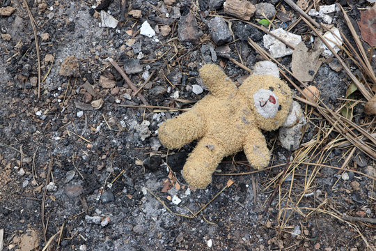 Old Dirty Teddy Bear Neglected On The Ground Soil. End Of Childhood.