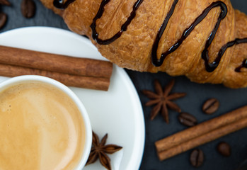 Breakfast set. Coffee with croissant decorated with cinnamon quilles and star anise