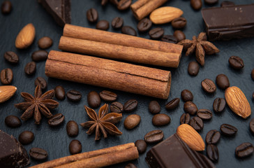 Spicy background. Warm christmas theme. Cinnamon quills, coffee beans and star anise and chocolate