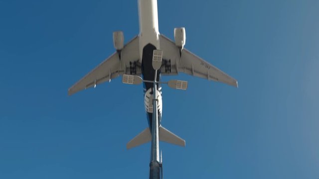 Passenger jet passes very close over street light on landing.