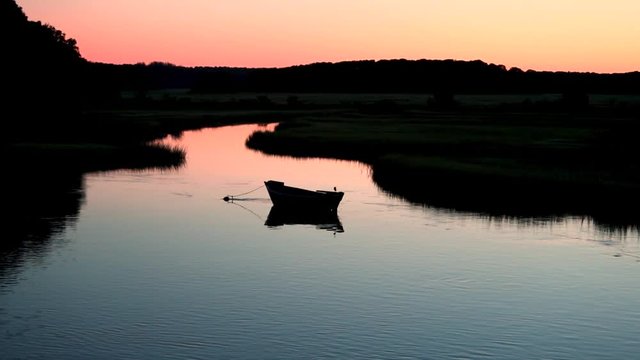 A beautiful wooden dory anchored in an inlet on Cape Cod just befor sunrise