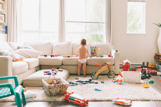 A Little Boy Playing In A Messy Living Room. 