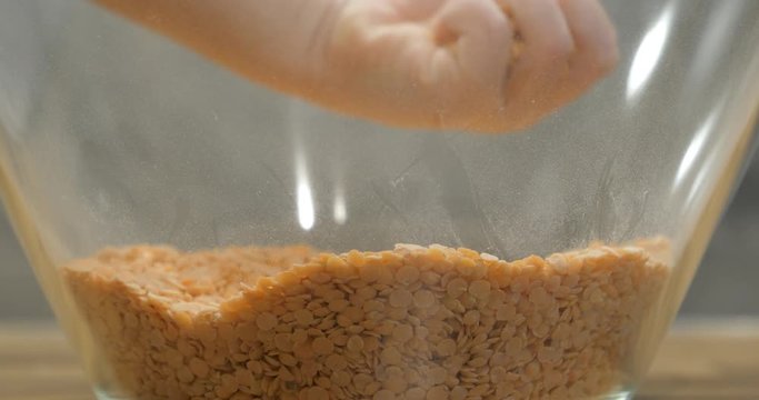 Toddler using bare hand to play with lentil seeds