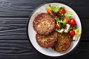 Delicious mushroom vegetable patties served with fresh salad on a plate close-up. horizontal top...