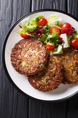 Healthy tasty food mushroom vegetable patty with fresh salad on a plate close-up. Vertical top view