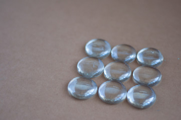 Clear marbles with light reflections on a brown background.