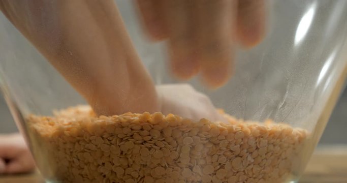 Toddler using bare hand to play with lentil seeds