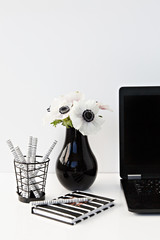 flowers in a vase in white desk